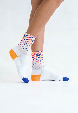 Weiße Socken mit mehrfarbigen Rautenmustern in Orange, Pink und Marineblau. Mit festem orangenem Fersen- und Zehenbereich sowie geripptem Bündchen.
