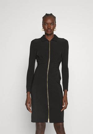 Black dress with long sleeves, collar, front zipper closure, fitted waist, and smooth fabric texture. Gold zipper detail is prominent.