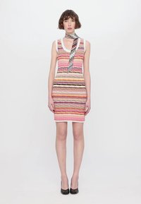 Daugiaspalvė dryžuota suknelė su apvalia iškirpte ir zigzago rašto šaliku. Iki kelių, prigludusi konstrukcija iš tekstūruotos medžiagos.