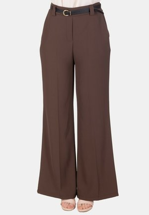 Pantaloni marroni a vita alta e gamba larga con piega frontale, abbinati a una cintura nera e sandali beige con punta aperta.