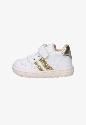 Witte peutersneaker met gouden glinsterstrepen, beige zool, klittenbandsluiting en metalen gouden hielpatch.