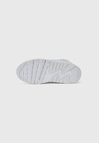 Weiße Sportschuhsohle mit strukturiertem Grip, die ein wellenförmiges Design und rechteckige Muster aufweist. Das Material scheint gummiert zu sein für Langlebigkeit.