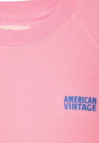 Felpa girocollo rosa con la scritta blu "AMERICAN VINTAGE" stampata sulla parte sinistra del petto.