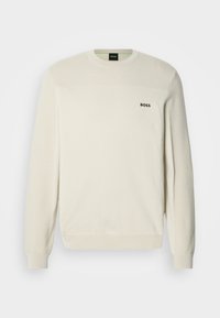 Krém színű, kerek nyakú pulóver texturált anyagból, bordázott mandzsettákkal és szegéllyel. A mellrészen fekete "BOSS" logóval.