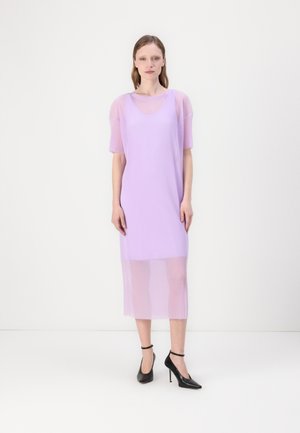 Lavendel geribbelde midi-jurk met korte mouwen en doorschijnende overlay. Zwarte hoge hakken accentueren de outfit. Eenvoudig, recht gesneden ontwerp.