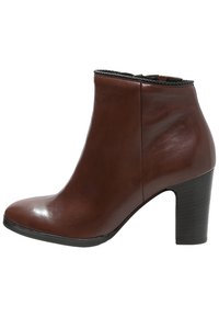 Ruskeat nahkaiset nilkkurit, joissa on sileä pinta, pyöreä kärki ja paksu korko. Näissä on myös teksturoitu musta reunus ylhäällä.