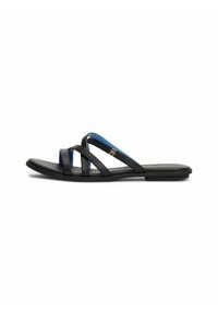 Svarta platta sandaler med korsade remmar som har en blå accent och subtil logodetalj. Materialet verkar mjukt och flexibelt.