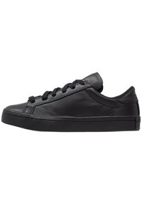 Black leather sneakers with a low-top design, rounded toe, and flat rubber sole. Features flat black laces and smooth texture throughout.