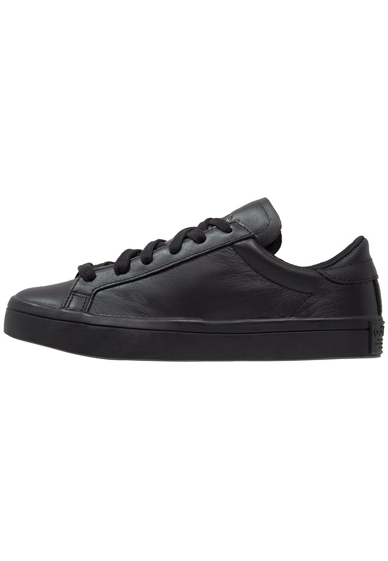 Black leather sneakers with a low-top design, rounded toe, and flat rubber sole. Features flat black laces and smooth texture throughout.