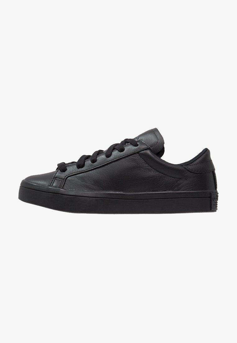 Black leather sneakers with a low-top design, rounded toe, and flat rubber sole. Features flat black laces and smooth texture throughout.