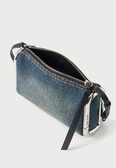 Petite pochette rectangulaire en denim avec fermeture éclair argentée et sangle en cuir noir avec boucle argentée et logo Marc Jacobs.