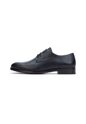 Zapato de vestir de cuero negro con un acabado liso, punta redonda, cinco ojales y un tacón bajo. Diseño simple con acentos mínimos.