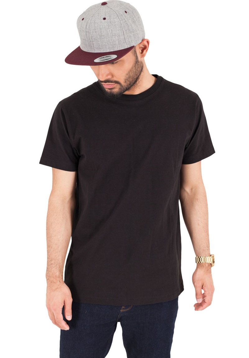 Maglietta nera in cotone a maniche corte, abbinata a un cappellino grigio e bordeaux con sei pannelli e visiera piatta. Vestibilità casual.