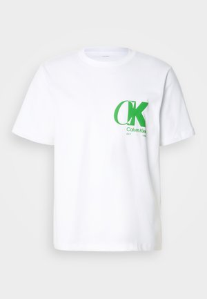 T-shirt en coton blanc avec un logo CK vert sur la poitrine gauche. Design classique à col rond avec des manches courtes et un ourlet droit.