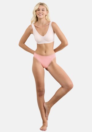 Reggiseno wireless rosa chiaro con spalline larghe e scollo a V profondo, abbinato a slip rosa coordinati a vita alta con rifinitura in pizzo.