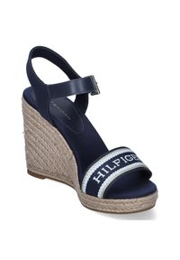 Sandalia cuña navy con tacón de yute trenzado, tira ancha con acentos en blanco y plateado, y correa de tobillo ajustable hecha de material suave.