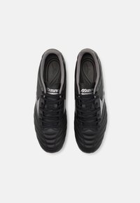 Scarpe da calcio nere con una tomaia in pelle testurizzata, dotate di un design con lacci e un interno grigio, caratterizzate da accenti di branding bianchi.