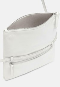 Biała skórzana torba na ramię z zamkiem błyskawicznym na górze i kieszenią z przodu, charakteryzująca się gładką teksturą i minimalistycznym designem.