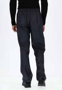 Zwarte waterdichte broek met een elastische tailleband en een glad, glanzend textuur. Met een relaxte pasvorm en verstelbare boorden.
