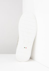 Weiße Sneakersohle mit einem strukturierten, geriffelten Muster. Verfügt über ein Logo und ein kleines Detail der italienischen Flagge. Die Farbgebung ist hauptsächlich weiß mit subtilen Akzenten.