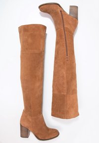 Stivali alti in suede marrone con zip laterale e tacco in legno spesso, mostrati da viste laterali e inferiori su sfondo bianco.