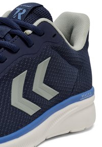 Granatowe buty sportowe z siateczkowej cholewki, jasnoszarymi detalami, niebieską podeszwą środkową oraz skomplikowanym wzorem bieżnika na podeszwie.