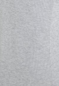 Šedá ribbová látka s jemnou texturou, která má vertikální pruhy a tlumený vzor, vytvářející hladký a jednotný vzhled.