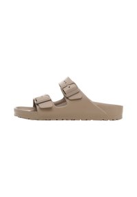 Beige rubberen sandalen met twee verstelbare bandjes, een gestructureerde voetbed en een lichtgewicht ontwerp. De zool heeft een gemarmerde grip voor tractie.