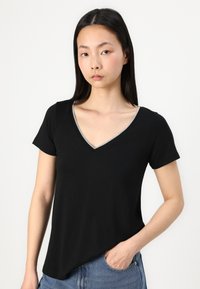 Black V-neck t-shirt featuring short sleeves, a silver-accented neckline, and a relaxed fit, made from soft cotton fabric.