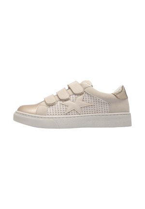 Baskets beiges avec un panneau en maille, des accents métalliques et trois bandes Velcro. Elles possèdent une semelle texturée et un design unique en forme d'étoile sur le côté.