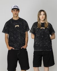 T-shirt oversize in cotone nero lavato acido con logo "JACKET"; abbinato a pantaloni shorts in denim nero. Il modello indossa un cappellino bianco con dettagli blu navy.