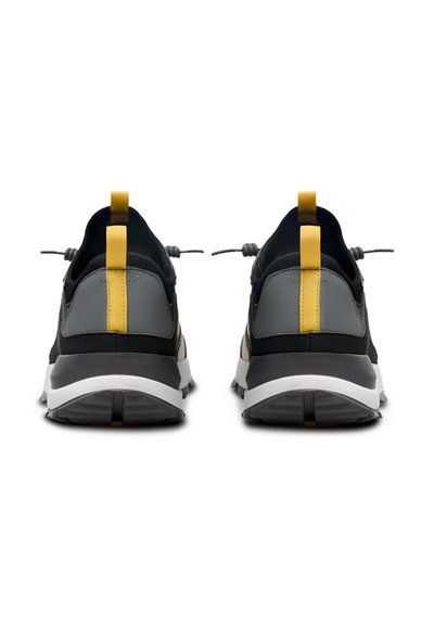 Black and gray athletic shoes featuring a yellow heel tab, textured upper, elastic lacing system, and a white midsole with a rubber outsole.