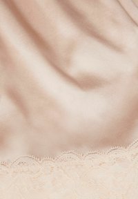 Satin stof in lichtroze met een gladde textuur, voorzien van een delicaat kantafwerking aan de onderkant met bloemenpatronen en gegolfde randen.