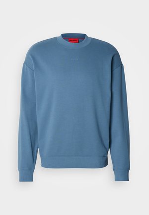 Helehall sinine pehme materjalist pusa, millel on ümmargune kaelus, pikad varrukad ja õrn logo detail rinnal.