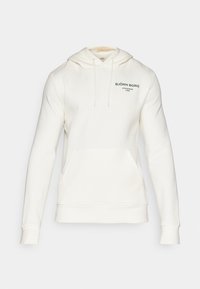 Kapuzensweatshirt in Cremefarbe, aus weichem Material gefertigt. Verfügt über eine Fronttasche, gerippte Bündchen und ein in Grün auf der Brust gedrucktes Logo.