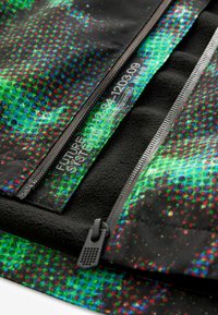 Veste zippée noire avec un motif moucheté multicolore en vert et rouge. L'intérieur est doublé d'une polaire texturée.