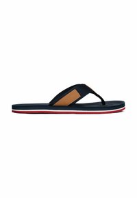 Tongs bleu marine avec un accent en cuir brun, dotées d'une semelle en caoutchouc avec des détails rouges et blancs et d'une semelle intérieure texturée pour plus d'adhérence.
