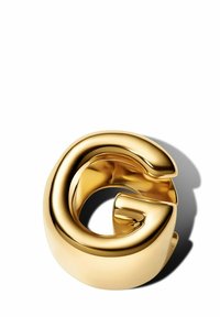 Anello d'oro a forma di lettera "G," con una superficie liscia e lucida, bordi arrotondati e un centro aperto per flessibilità.