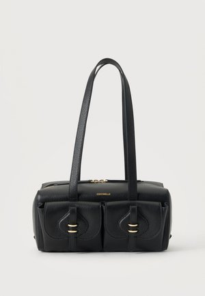 Sac à main en cuir noir avec deux poches sur le devant, ferrures dorées et doubles bretelles, sur fond blanc uni.