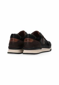 Scarpe da ginnastica nere e marroni con pelle testurizzata, dettagli lisci e suole beige, dotate di un logo sul tallone e cuciture a contrasto.