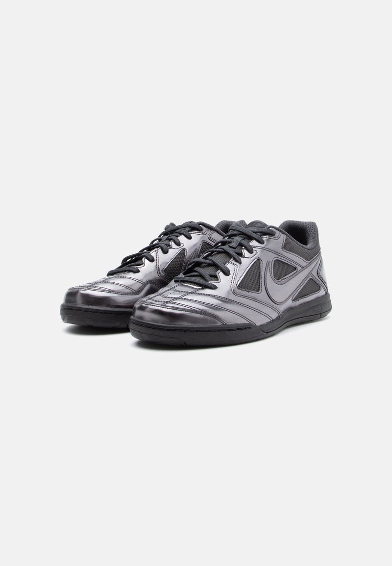 Schwarze Sportschuhe mit glänzender Oberfläche, ausgestattet mit einem strukturierten Obermaterial, Mesh-Details und schwarzen Schnürsenkeln. Gepflegte Form und Gummisohle.