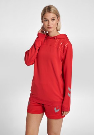 Red athletic hoodie with a textured upper panel featuring shiny accents, paired with red shorts displaying a logo in gray.