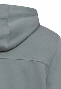 Szara bluza z kapturem o gładkiej fakturze, wyposażona w przestronny kaptur, płaskie szwy i minimalistyczny design. Skupienie na materiale i kolorze.