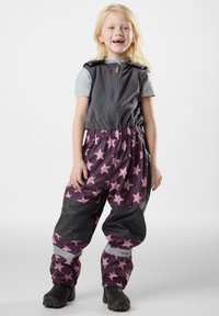 Grijze vest met een rits, gecombineerd met waterdichte, roze overall met sterpatroon en zwarte accenten en elastische boorden. Zwarte laarzen.