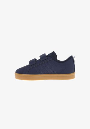Zapatilla deportiva azul marino con dos tiras de velcro, detalles laterales cosidos, forro interior negro y suela de goma marrón claro.