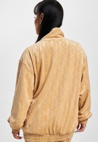 Karl Kani CHEST SIGNATURE MONOGRAM VELVET - Sportinė striukė - sand