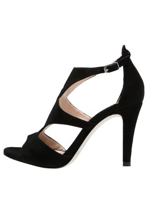 Sorte ruskind højhælede sandaler med åben tå, krydsgående stropper og en ankelrem med spænde. Har et slankt design og en struktureret overflade.