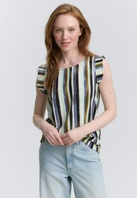 Top senza maniche a righe con scollatura rotonda nei toni del blu, verde e marrone; tessuto strutturato; dettagli arruffati sulle spalle; abbinato a jeans chiari.