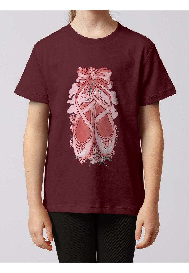 Enfant portant un t-shirt bordeaux avec des chaussons de ballet roses noués de rubans et entourés de petites fleurs.