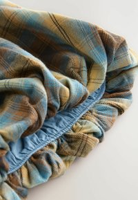 Gecoördineerde stof met blauwe, bruine en gele tinten; elastische tailleband met plooidetail; zachte, gestructureerde stof met een gerimpelde rand.
